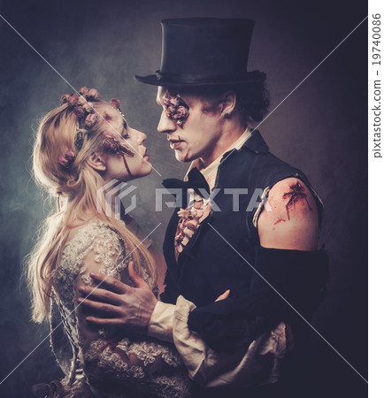 Dressed in wedding clothes romantic zombie couple walking on the abandoned cemetery. 19740086