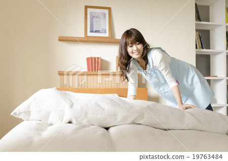 A woman making a bed A woman making a bed 19763484