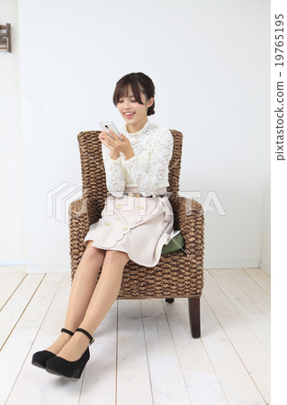 A young woman sitting on a chair A young woman sitting on a chair 19765195