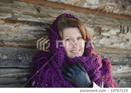 The Russian woman in shawl warms hands near an The Russian woman in shawl warms hands near an 19767220