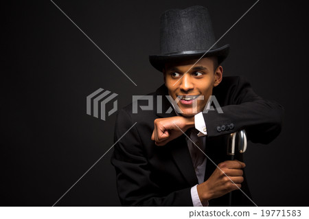 Handsome man in top hat posing with cane Handsome man in top hat posing with cane 19771583