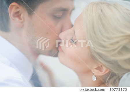 love the bride and groom are covered with a veil and kiss love the bride and groom are covered with a veil and kiss 19773170