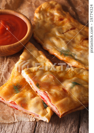 Cut Italian pizza calzone with ham and cheese 19774324