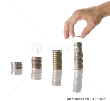 Hand holding and adding a coin on the stacks of mix coins on whi 19778648