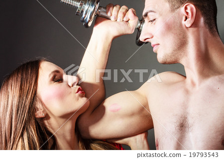 Couple muscular man and girl admiring his strength. Couple muscular man and girl admiring his strength. 19793543