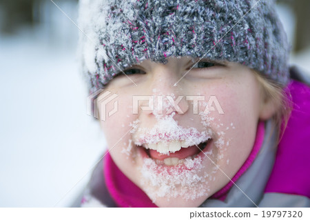 Little girl in winter season with hat in snow. 19797320