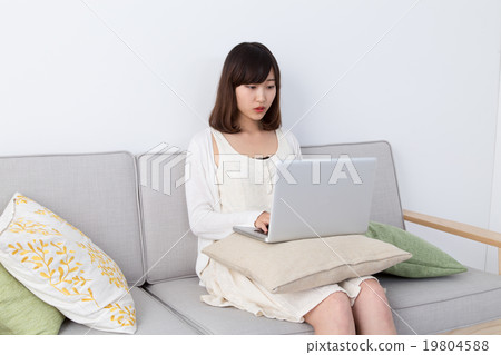 在房間裡玩個人電腦的女人 19804588
