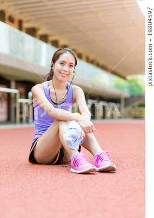 Young woman take rest after running at sport arena 19804597