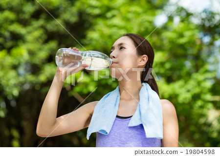 Young woman having rest after sport exercises holding bottle of Young woman having rest after sport exercises holding bottle of 19804598