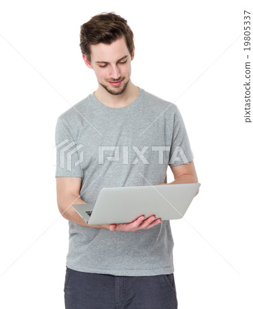Smiling young man working on laptop Smiling young man working on laptop 19805337