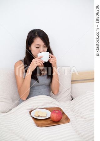 Young Woman having breakfast on bed 19806206