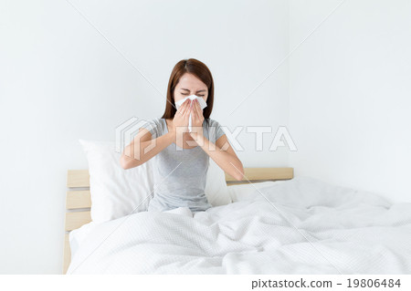 Young lady sneeze on the bed and need more rest 19806484