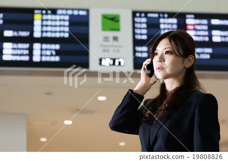 Business woman in front of airport timetable 19808826