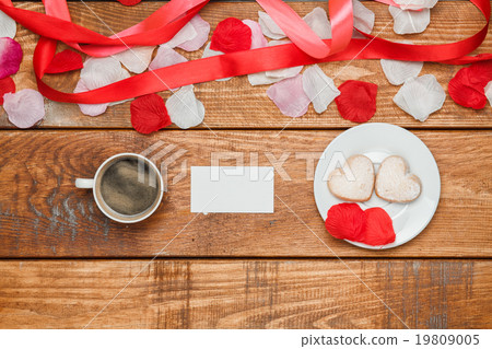 The red ribbon on wooden background with a cup The red ribbon on wooden background with a cup 19809005