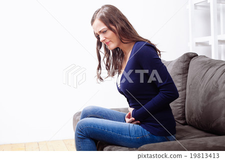 Young Woman Sitting and Suffering From Ache Young Woman Sitting and Suffering From Ache 19813413
