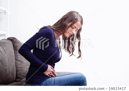 Young Woman Sitting and Suffering From Ache Young Woman Sitting and Suffering From Ache 19813417