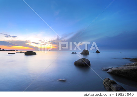 Sunrise at rocky beach. 19825040