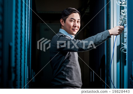 Young engineer businessman in server room Young engineer businessman in server room 19828443