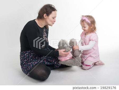 Mother explains to daughter a kiss on toys Mother explains to daughter a kiss on toys 19829176