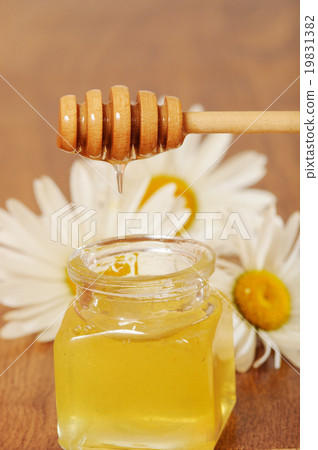 jar of honey and a spoonful of honey with daisies jar of honey and a spoonful of honey with daisies 19831382