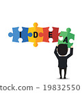 Businessman holding up jigsaw puzzle pieces. 19832550