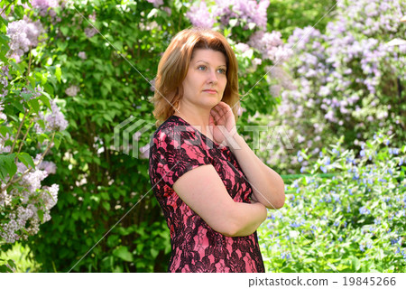 Middle-aged woman near blossoming lilac 19845266
