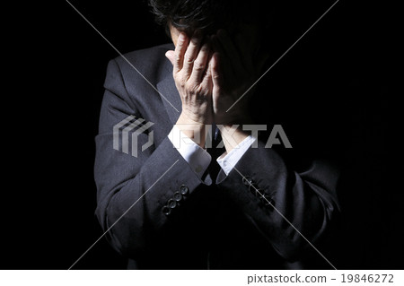 Middle-aged businessman holding a head 19846272