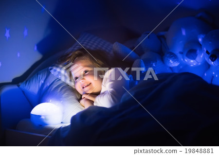 Little girl reading a book in bed 19848881
