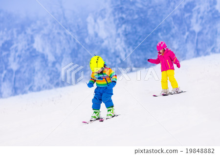Two children skiing in snowy mountains Two children skiing in snowy mountains 19848882