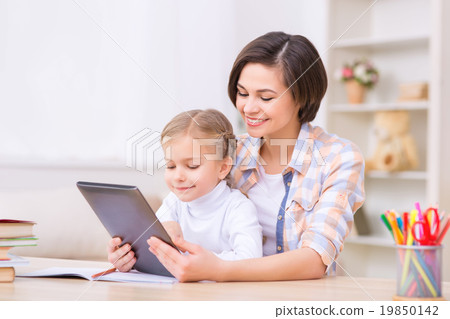 Mom and daughter are using portable tablet. Mom and daughter are using portable tablet. 19850142
