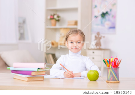 Little girl is sitting at the desk and doing Little girl is sitting at the desk and doing 19850143