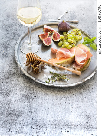 Wine appetizer set. Glass of white wine, honeycomb 19850796