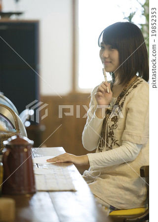 A woman writing a letter at a cafe A woman writing a letter at a cafe 19852353