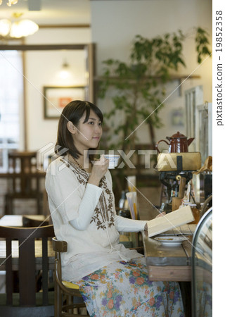 在咖啡廳喝咖啡的婦女 在咖啡廳喝咖啡的婦女 19852358