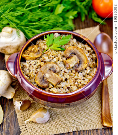 Buckwheat with champignons in clay bowl on sacking 19856398