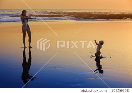 Mother with little child on the sunset sea beach 19856698
