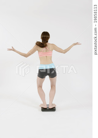A young lady getting down on the scale 19858113
