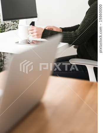 A woman working from home, drinking coffee. A woman working from home, drinking coffee. 19860000