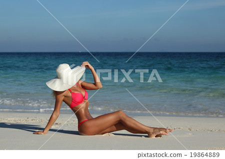 Woman sitting on the beach 19864889