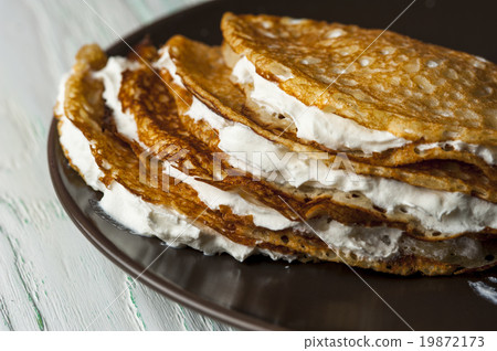Pancakes with whipped cream on brown plate Pancakes with whipped cream on brown plate 19872173
