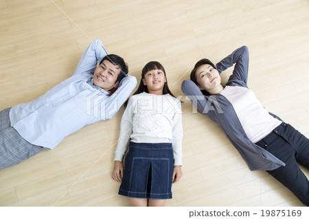 A bird's-eye view of the three parents and children lying on the floor 19875169