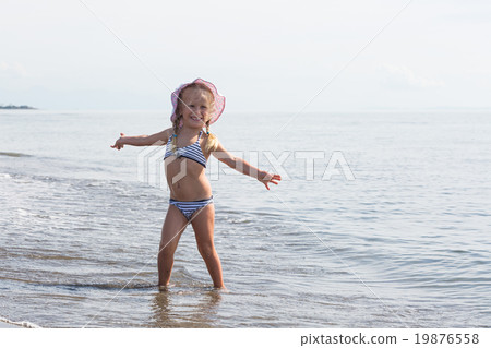 girl sits at the water's edge girl sits at the water's edge 19876558