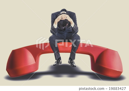 男子坐在紅色的手機上,麻煩 男子坐在紅色的手機上,麻煩 19883427