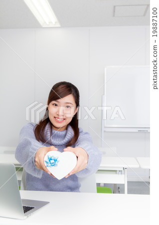 A woman with a heart-shaped gift box A woman with a heart-shaped gift box 19887100