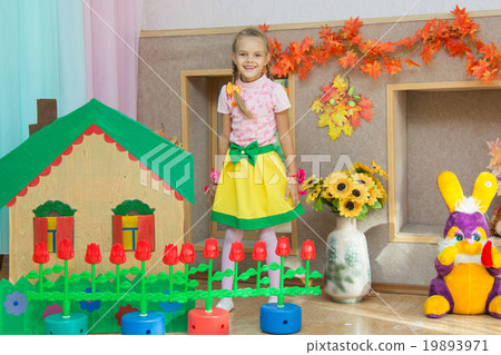 Six year old girl stands in the scenery of a country house on the matinee in kindergarten Six year old girl stands in the scenery of a country house on the matinee in kindergarten 19893971