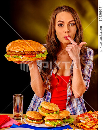 Girl eating big sandwich. 19899674