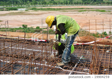 Construction workers fabricating beam reinforcemen Construction workers fabricating beam reinforcemen 19904259