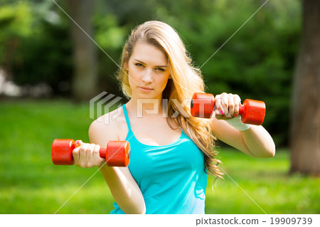 Sports girl exercise with  dumbbells in the park 19909739