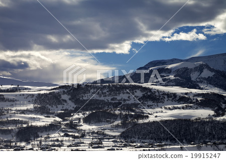 Winter mountains and village at evening 19915247