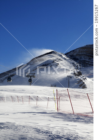 Gondola lift on ski resort at windy sun day 19915267